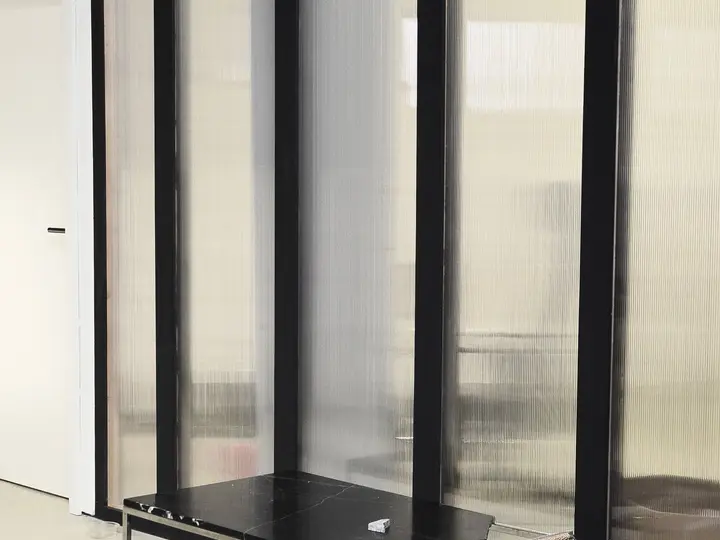 Framed glass partition with dark aluminium profiles