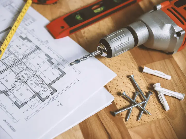 Floor plans, tape measure and tools on a site table